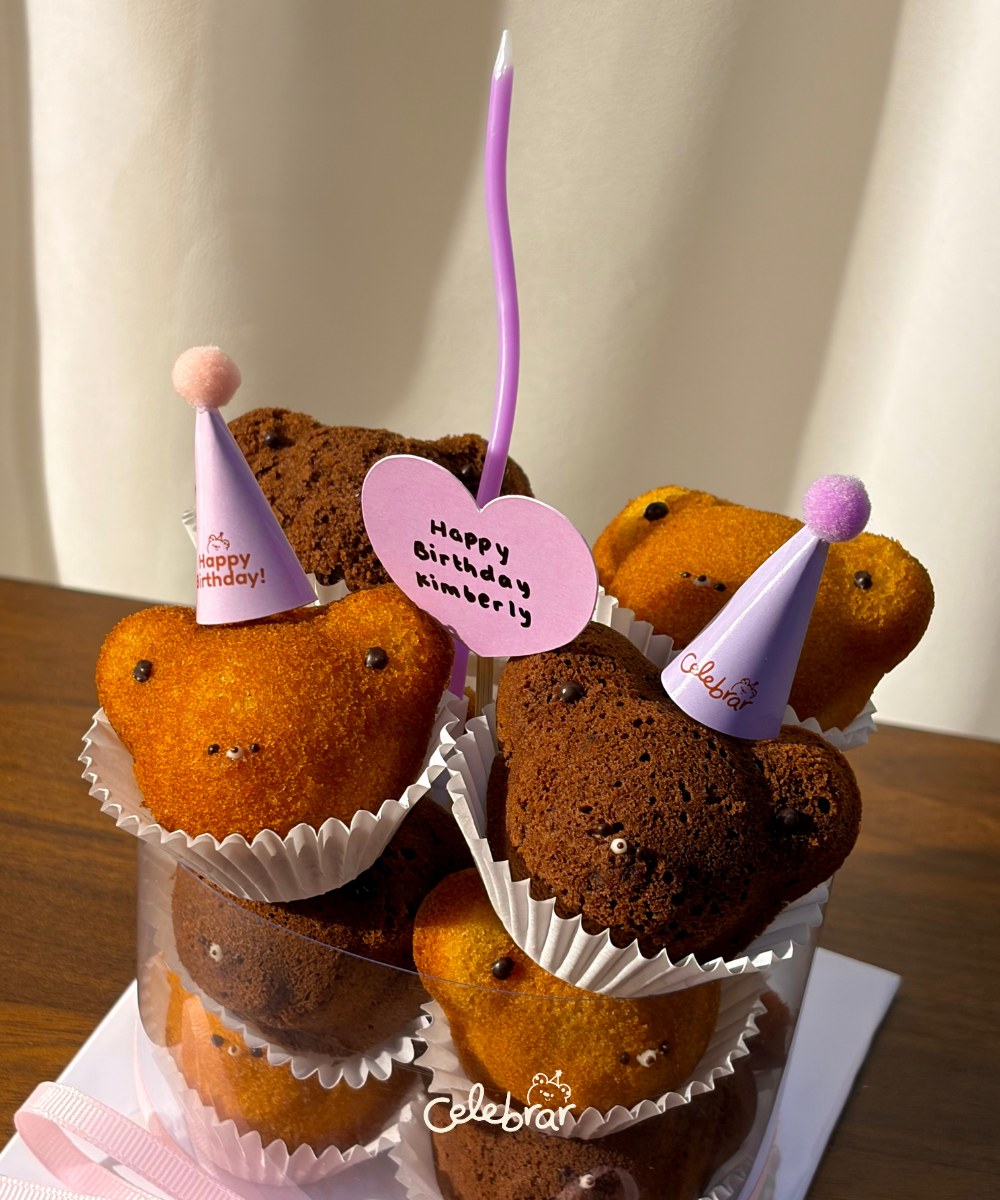 Close-up of Teddy Stack madeleines with party hats and message tag